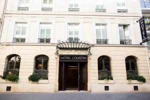 un bâtiment blanc avec un panneau de liaison hôtel dans l'établissement Hotel Louison, à Paris