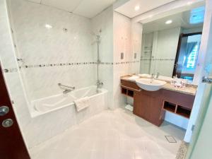 a bathroom with a tub and a sink at Elegant and spacious 1bed with 2 balconies in JLT - LAKV in Dubai