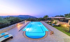 a swimming pool in the middle of a backyard at Villa Stelios Private Pool in Georgioupolis