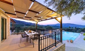 taras ze stołem i krzesłami oraz basenem w obiekcie Villa Stelios Private Pool w mieście Georgioupolis