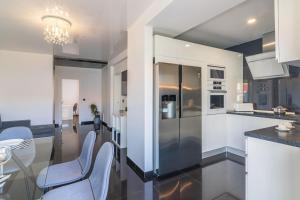 una cucina con mobili bianchi, tavolo e sedie di Vilamoura Premium Apartment by Homing a Vilamoura