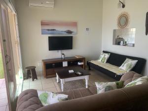 a living room with a couch and a tv at Seaview on Shelly in Margate
