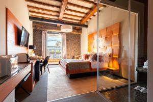 een slaapkamer met een bed, een bureau en een televisie bij Ara di Marte Suites in Rome