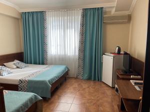 a hotel room with two beds and a television at Sadko na Astrakhanskoy in Anapa