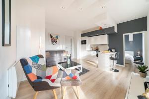 a living room with a table and chairs and a kitchen at Frontière Monaco, Appartement Rénové Entièrement - AG in Beausoleil