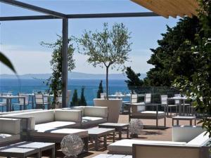 een patio met banken en tafels en uitzicht op de oceaan bij Apartment Happy Day in Split