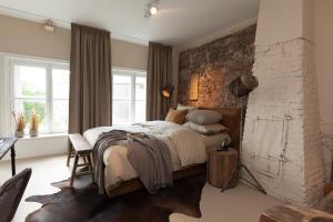 a bedroom with a bed and a brick wall at Mother Goose Hotel in Utrecht