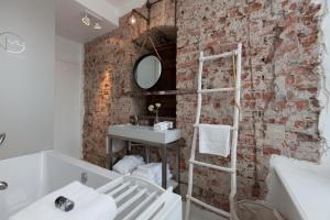 a brick wall in a bathroom with a sink and a mirror at Mother Goose Hotel in Utrecht +56 photos