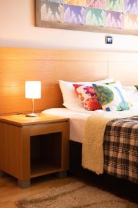 a bed with a table with a lamp on it at Vučko Apartment 107 Jahorina in Jahorina