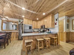 a kitchen with wooden cabinets and a island with bar stools at Timberwolf Lodge 6 cabin in Park City