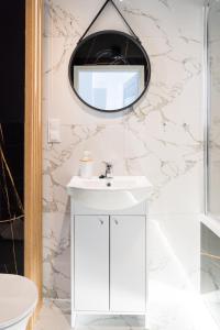 La salle de bains est pourvue d'un lavabo et d'un miroir. dans l'établissement Apartament Hania, à Gdańsk