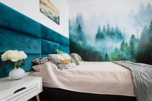a bedroom with a bed with a painting on the wall at Apartament Hania in Gdańsk