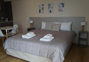 a bedroom with a bed with two towels on it at Apart Hotel Quijote by DOT Suites in Ciudad Lujan de Cuyo +43 photos