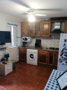 a kitchen with a white washer and a stove at A casinha do Pescador in Nazaré