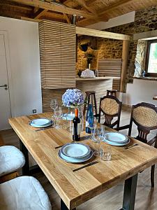 una mesa de madera con platos y copas de vino. en Rectoral de Boente, en Arzúa