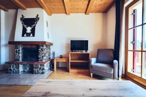 a living room with a fireplace and a tv at Pohorje Village Wellbeing Resort - Family Apartments Bolfenk in Hočko Pohorje