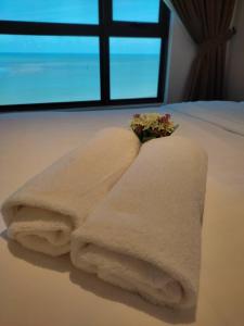 einen Stapel Handtücher auf dem Bett in der Unterkunft SEAVIEW Studio with KING BED at Imperium Residence, Kuantan in Kuantan