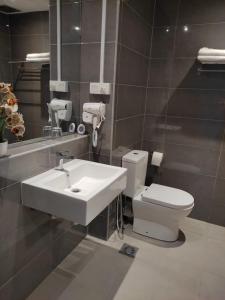 ein Badezimmer mit einem Waschbecken, einem WC und einem Spiegel in der Unterkunft SEAVIEW Studio with KING BED at Imperium Residence, Kuantan in Kuantan