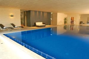a large blue swimming pool in a hotel room at Landhotel Allgäuer Hof in Wolfegg