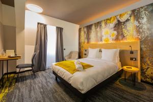 a hotel room with a bed and a desk at Berti Hotel - Mulhouse Centre Gare in Mulhouse