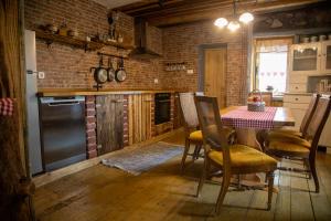 a kitchen with a table and a brick wall at Kuća za odmor Mećava in Mrkopalj