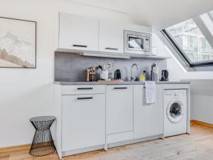 a white kitchen with a sink and a washing machine at limehome Hannover Bleichenstraße in Hannover
