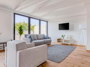 ein Wohnzimmer mit einem Sofa und einem TV in der Unterkunft limehome Hannover Bleichenstraße - Digital Access in Hannover