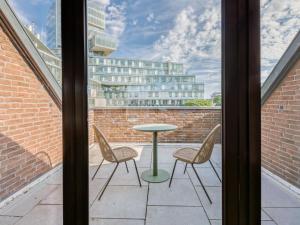 un balcón con mesa y sillas y un edificio en limehome Hannover Bleichenstraße - Digital Access en Hannover