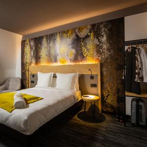a hotel room with a bed and a painting on the wall at Berti Hotel - Mulhouse Centre Gare in Mulhouse