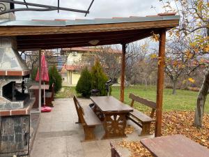 a wooden pavilion with a picnic table and a grill at Kot Garden Guest House in Sapareva Banya