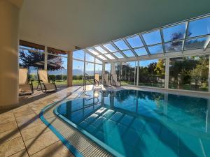 a swimming pool in a house with glass windows at DAS MATSCHER Residence & Garden Hotel in Appiano sulla Strada del Vino