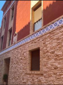 un edificio de ladrillo con azulejos azules y blancos. en Hostal Sara, en Villafeliche