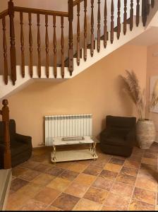 a living room with a staircase with two couches at Hostal Sara in Villafeliche