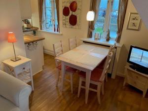 a kitchen and dining room with a table and chairs at Deichhof Whg 8 in Dunsum