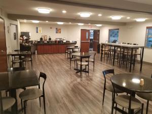 a restaurant with tables and chairs and a bar at Best Western Sandy Inn in Sandy