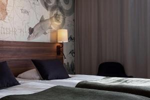 um quarto de hotel com uma cama e duas cadeiras em Scandic Täby em Täby