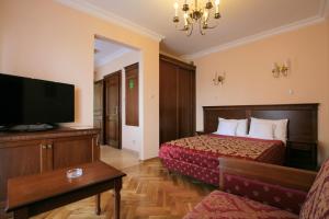 a hotel room with a bed and a flat screen tv at Apartamenty Furta Dominikańska in Sandomierz