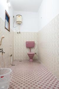 La salle de bains est pourvue de toilettes roses et d'un lavabo. dans l'établissement Deer Suites and Spa- Rock Beach White Town Zone , French Quarter, Pondicherry, à Pondichéry
