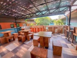 a restaurant with wooden tables and chairs in a room at 2 Home in Chalong