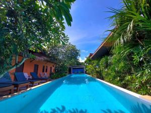 a swimming pool in a villa with palm trees at 2 Home in Chalong