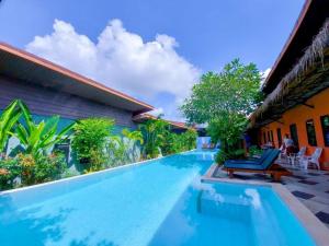a swimming pool in front of a house at 2 Home in Chalong