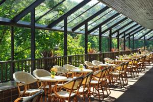 Hotel Toplice - Terme Krka في سمارجيسك توبليس: صف من الطاولات والكراسي في مبنى زجاجي