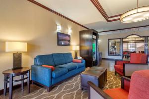 a living room with a blue couch in a hotel room at Comfort Suites Montgomery East Monticello Dr in Montgomery