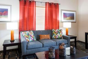 salon z kanapą i czerwonymi zasłonami w obiekcie Quality Inn & Suites Lake Charles South w mieście Lake Charles