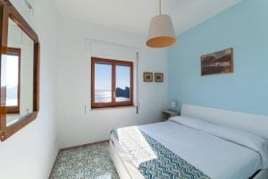 a white bedroom with a bed and a window at MAIN Roof Terrace Apartment in Nerano