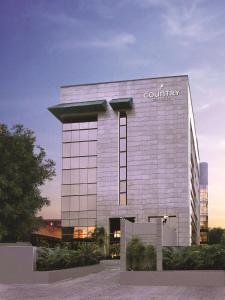 un bâtiment avec un panneau d'entreprise sur son côté dans l'établissement Country Inn & Suites by Radisson, Gurugram Sector 12, à Gurgaon