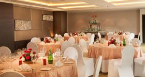 una sala de banquetes con mesas, sillas blancas y mesa en Park Inn By Radisson Gurgaon Bilaspur, en Manesar