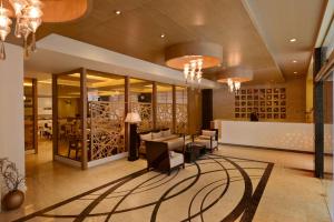 a lobby with couches and chairs and wine bottles at Country Inn Panjim Goa in Panaji