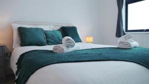 a bedroom with a bed with towels on it at Sapphire House Apartments in Telford