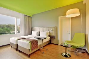 ニューデリーにあるPark Inn by Radisson,South Delhiのベッドルーム1室(ベッド1台、デスク、椅子付)